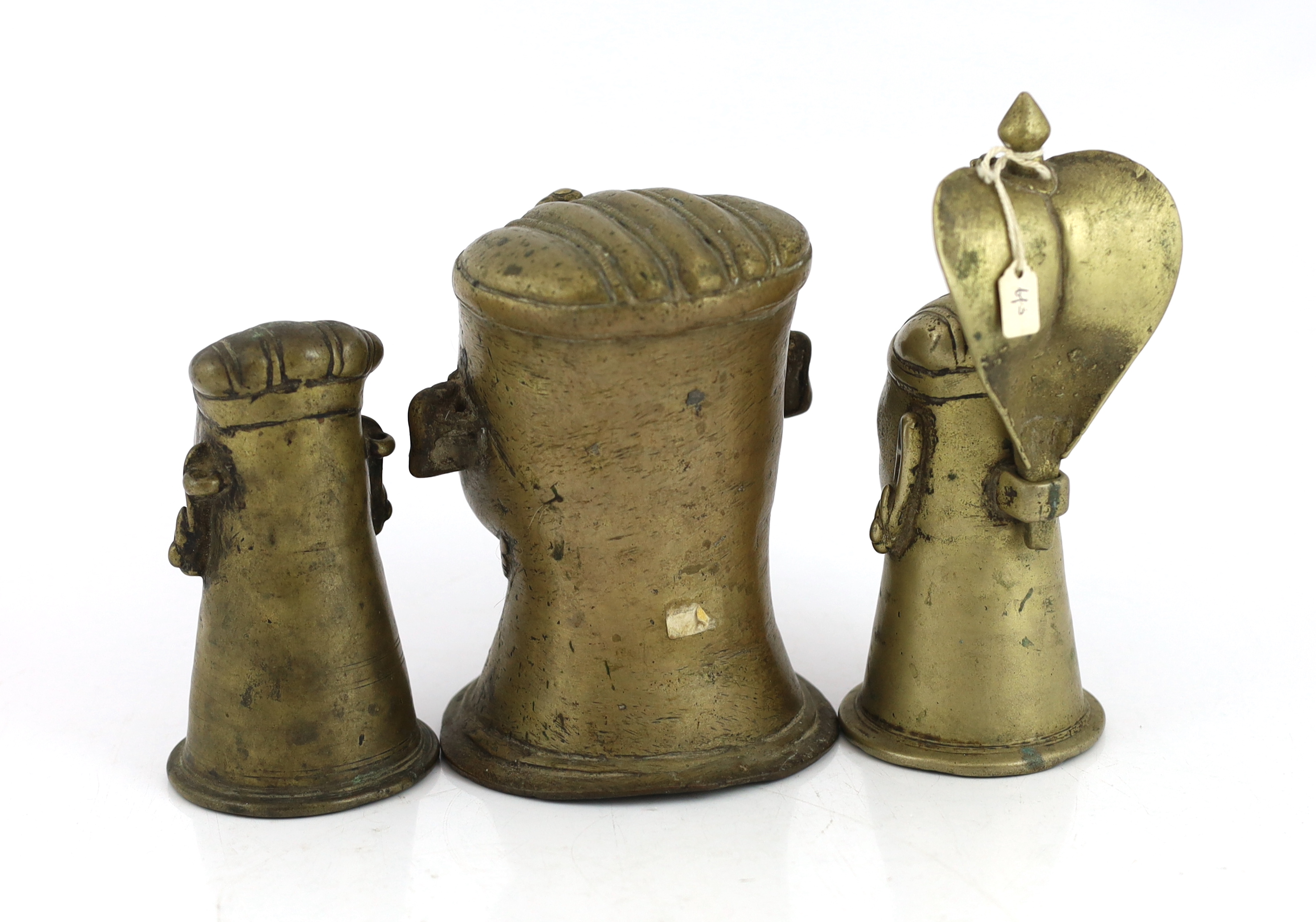 A group of three brass alloy Shiva Mukhalingam, Southern India, 16th-18th century, each depicting a Shiva head, wearing his characteristic moustache, earrings and matted hair, one example surmounted by a removable Naga (